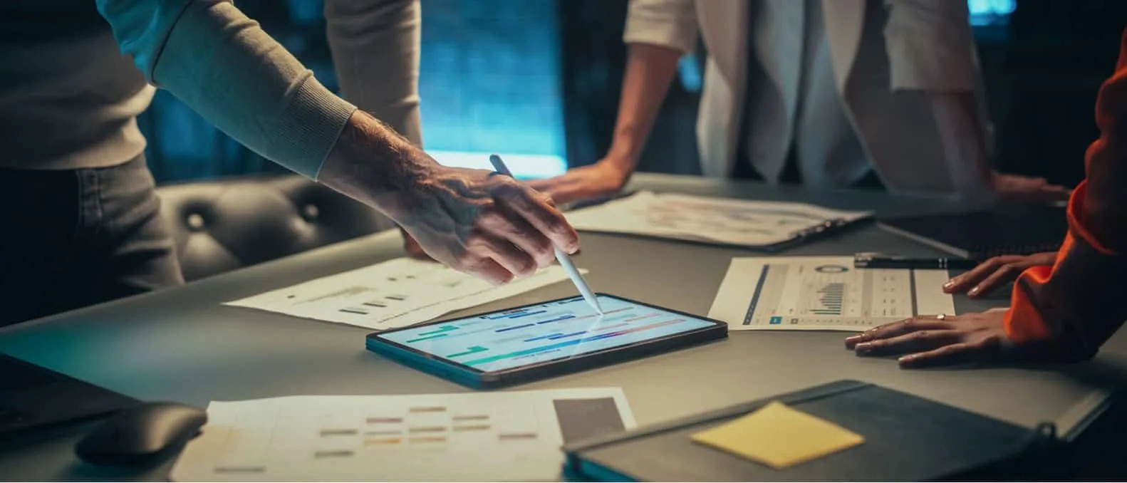 Stock image of people using a tablet during a meeting