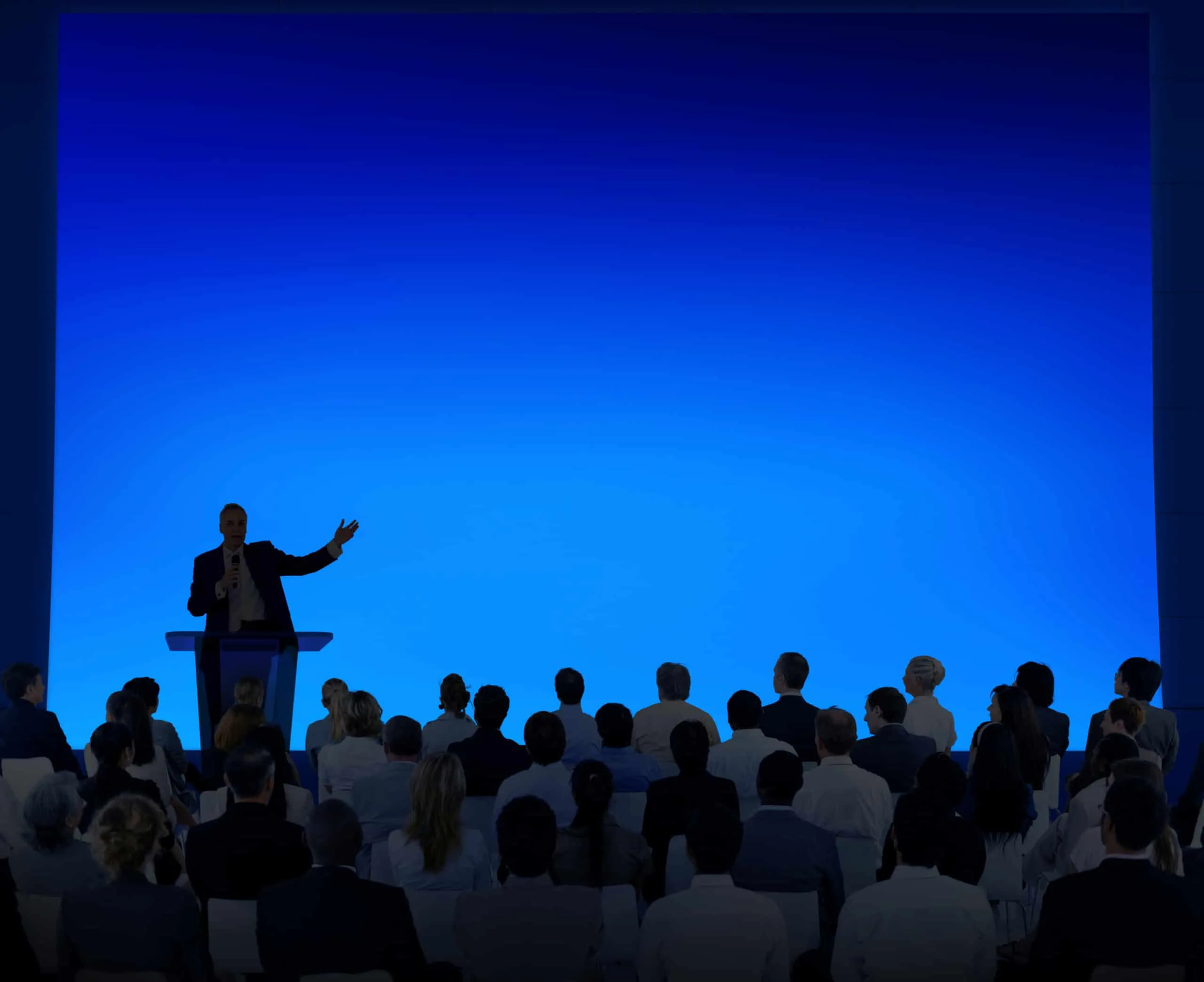 Stock image of people listening to a speech